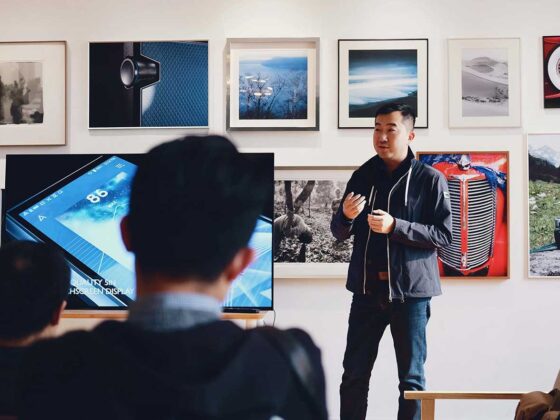 Product Owner leading a meeting with a mobile application on a tv screen