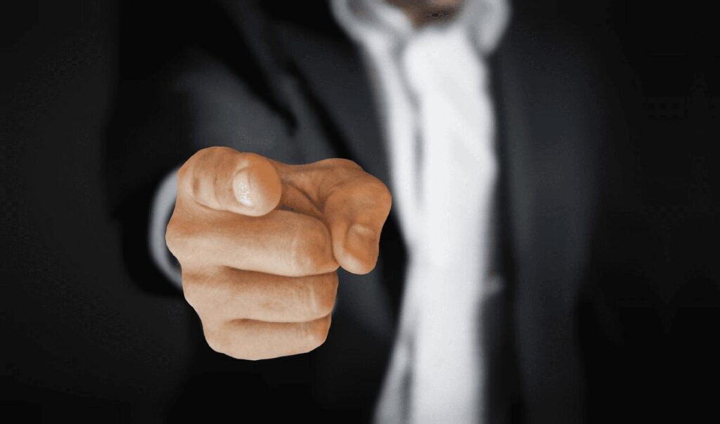 Picture of a man in a work suit pointing at the reader