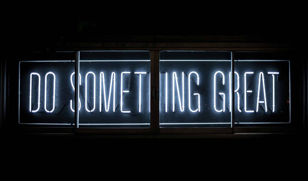 A fluorescent sign that reads "Do Something Great"