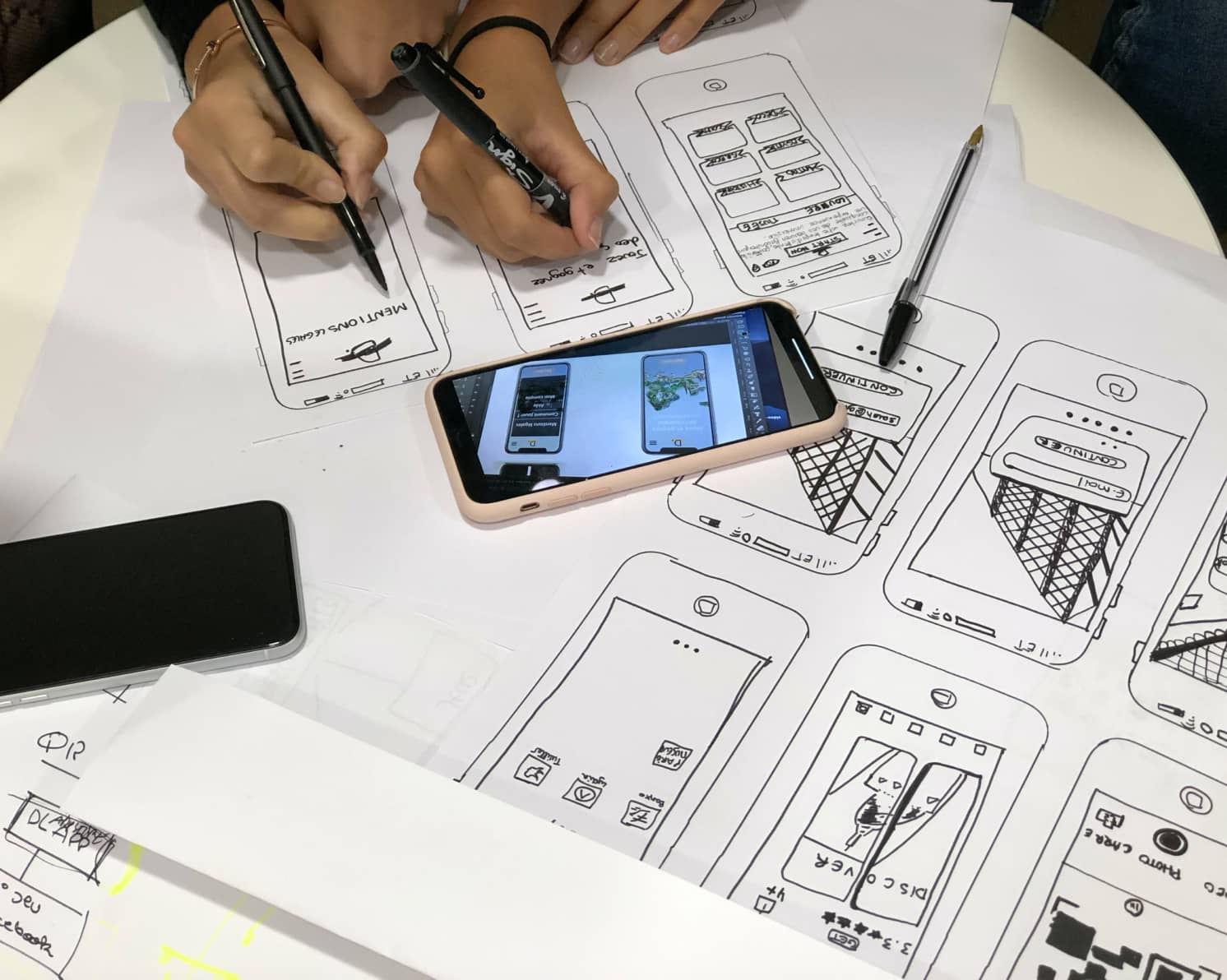 A person working on drawing wireframes on paper